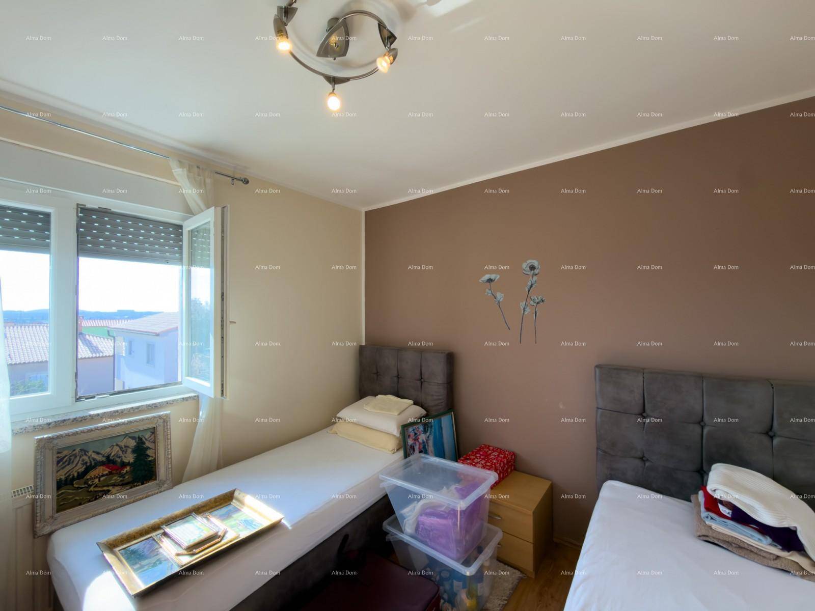Helles Schlafzimmer mit zwei Einzelbetten, brauner Akzentwand und Fenster.