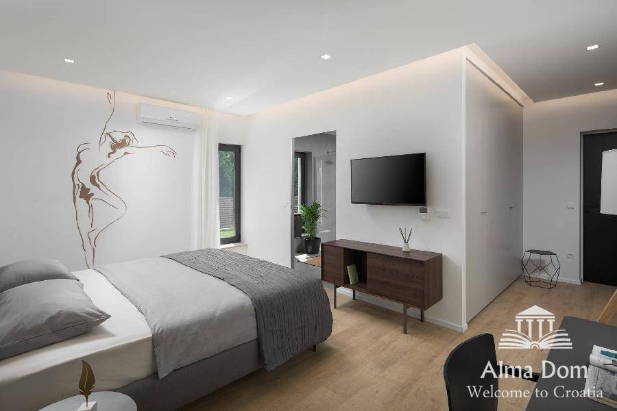 Helles Schlafzimmer mit modernem Dekor, Wandkunst und Klimaanlage für angenehmes Raumklima.
