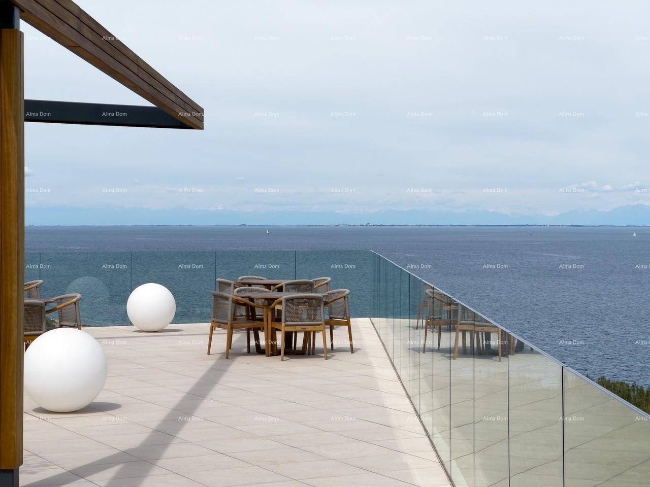 Stilvolle Außenterrasse mit Esstisch und dekorativen Kugeln, die einen herrlichen Blick auf das Meer bietet.