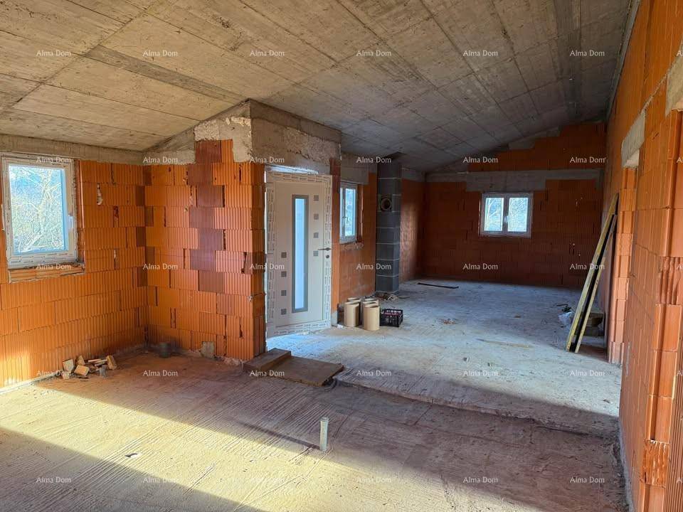 Unfertiger Innenraum mit Ziegelwänden, Betonboden und einer Eingangstür, die Tageslicht hereinlässt.