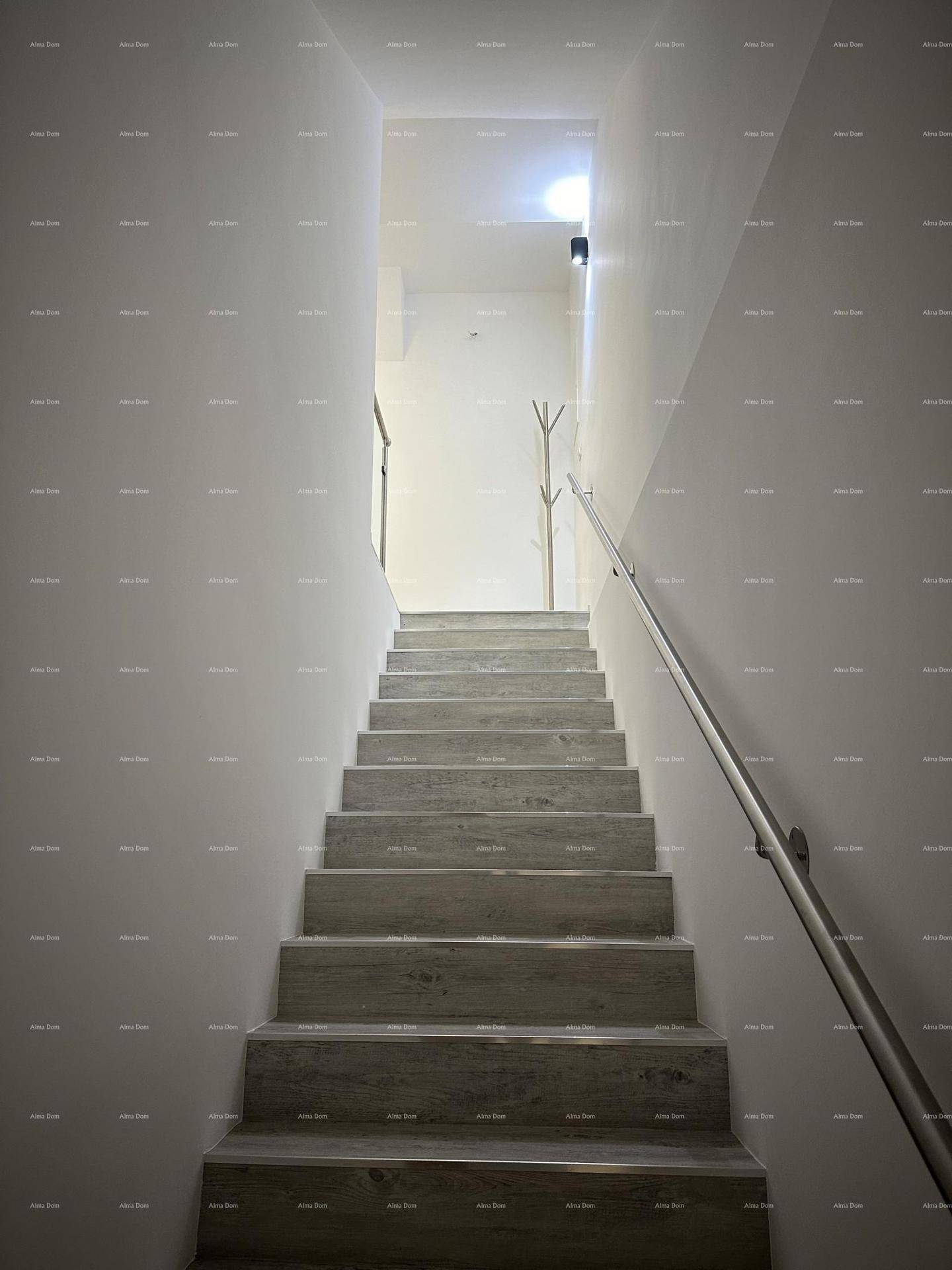 Heller Treppenaufgang mit Holzstufen und modernem Geländer, der in die obere Etage führt.