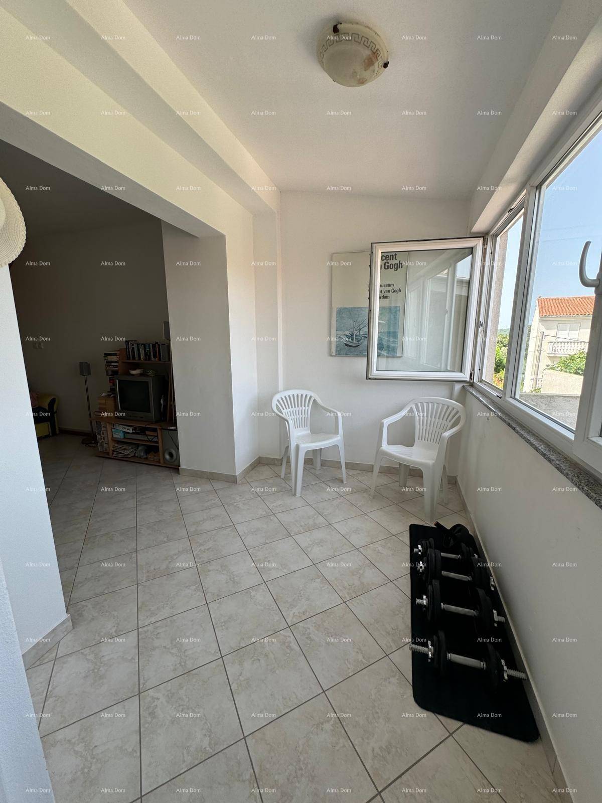 Kleiner Wohnbereich mit Fliesenboden, Fenster und einfacher Einrichtung, ideal zum Entspannen.