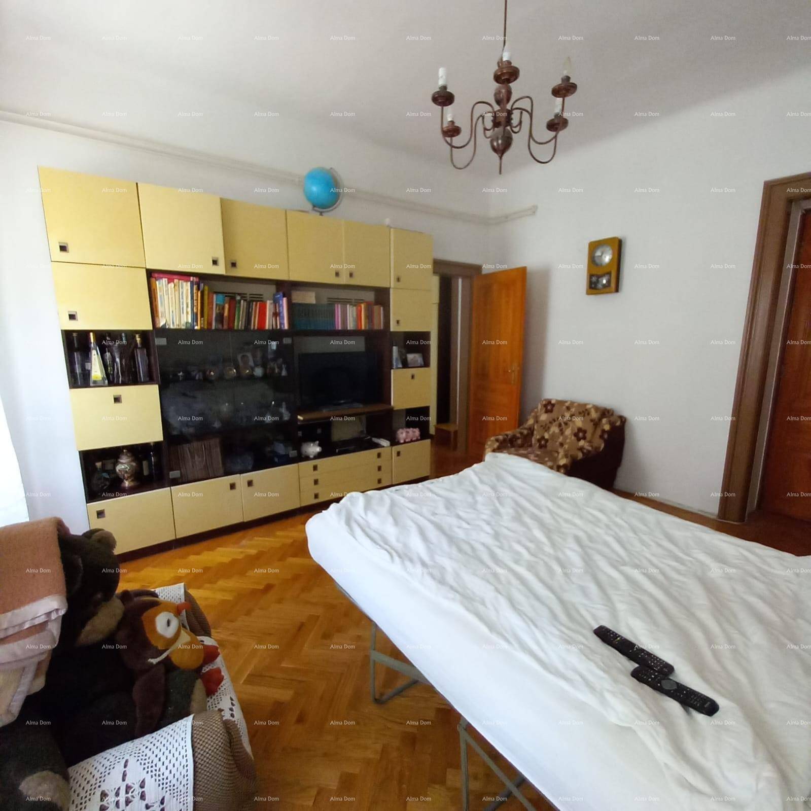 Schlafzimmer mit Parkettboden, großem Wandschrank und Kronleuchter.