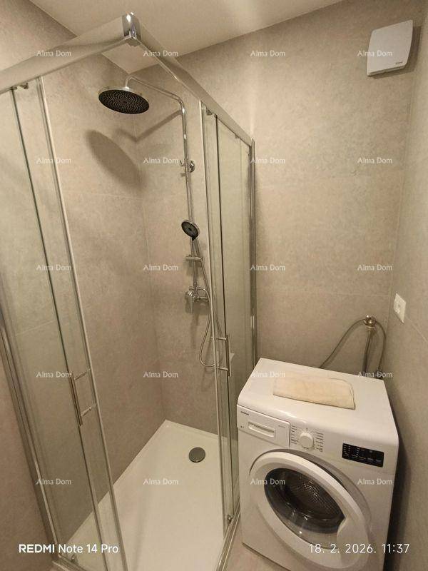 Modernes Badezimmer mit Duschkabine, Waschmaschine und hellen Fliesen.