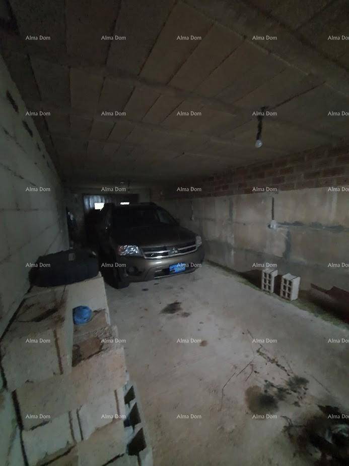 Garage mit Betonwänden und einem geparkten Auto, einfache Beleuchtung.