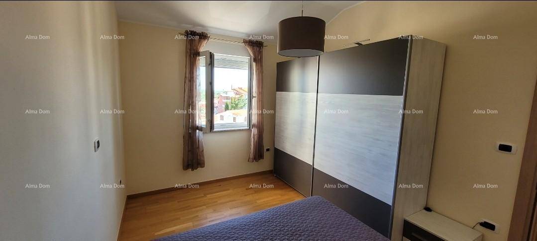 Schlafzimmer mit Holzboden, großem Kleiderschrank und einem Fenster mit Blick nach draußen.