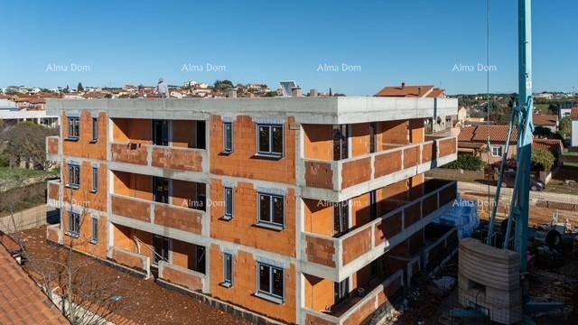 Neubau eines Mehrfamilienhauses im Rohbau mit sichtbaren Ziegelwänden und Balkonen unter blauem Himmel.