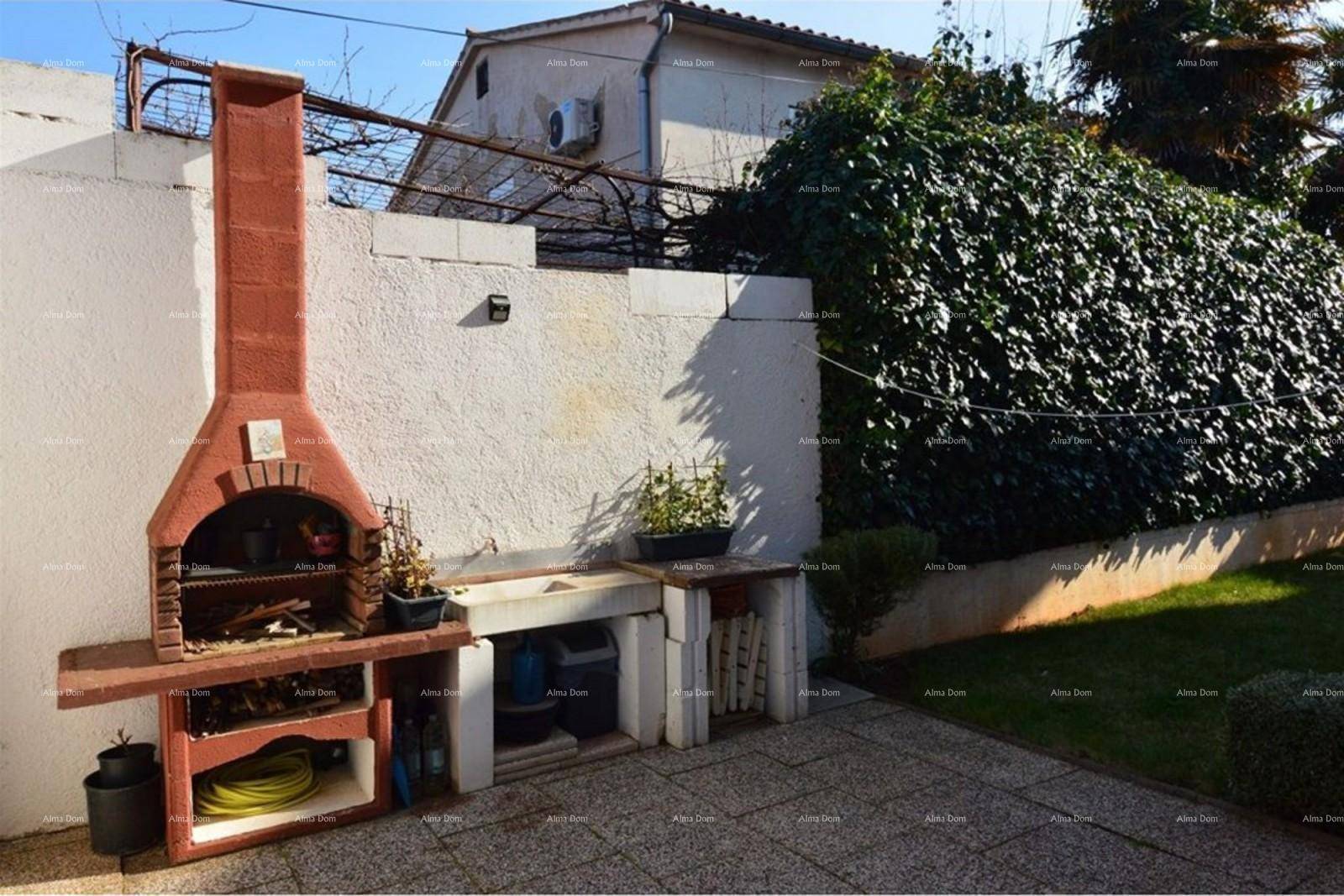 Gemauerter Grillplatz im Gartenbereich mit gepflasterter Fläche.
