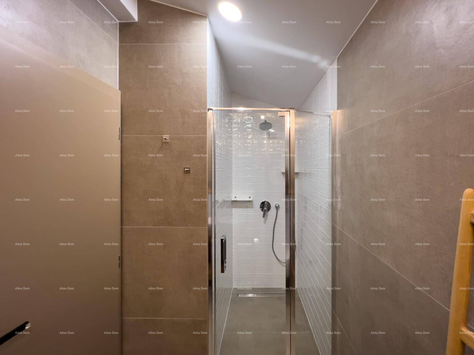 Duschbereich im Badezimmer mit Glasabtrennung und modernen grauen Fliesen, die Eleganz verleihen.