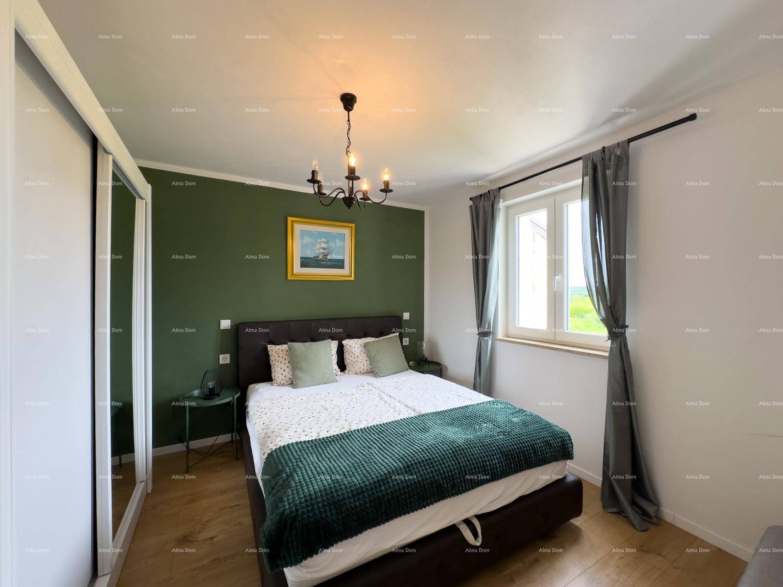 Gemütliches Schlafzimmer mit Doppelbett, grün gestrichener Wand und Schiebetürenschrank.