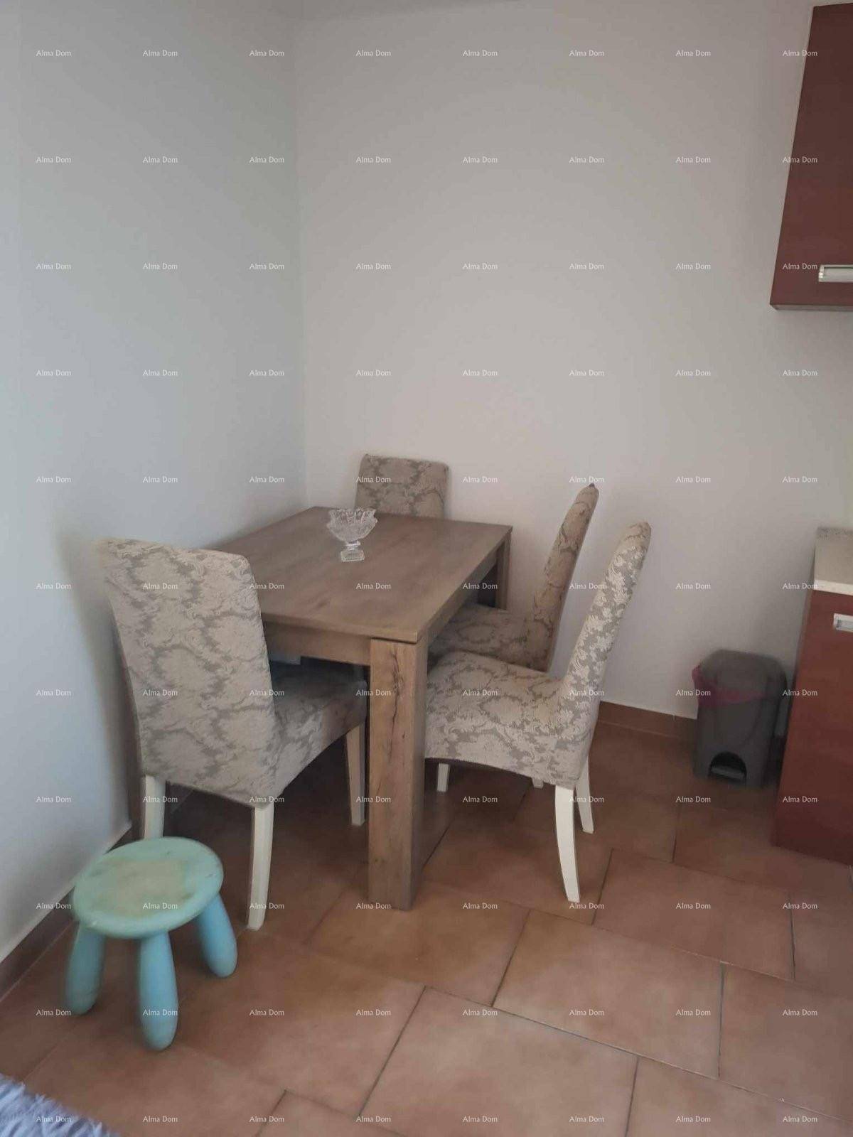 Gemütlicher Essbereich mit Holztisch und gepolsterten Stühlen auf Fliesenboden.