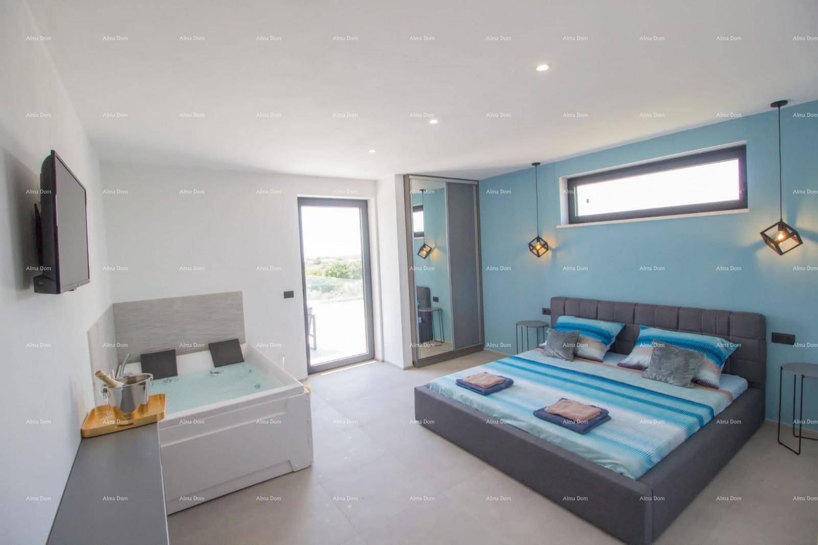 Schlafzimmer mit Whirlpool, modernem Bett und blauer Akzentwand für Entspannung.