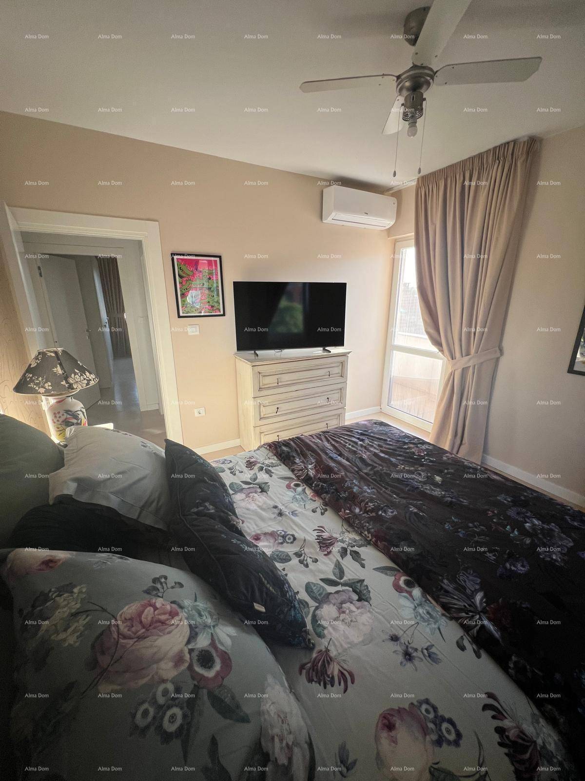 Gemütliches Schlafzimmer mit Doppelbett, TV auf Kommode, Deckenventilator und Klimaanlage für angenehmes Raumklima.