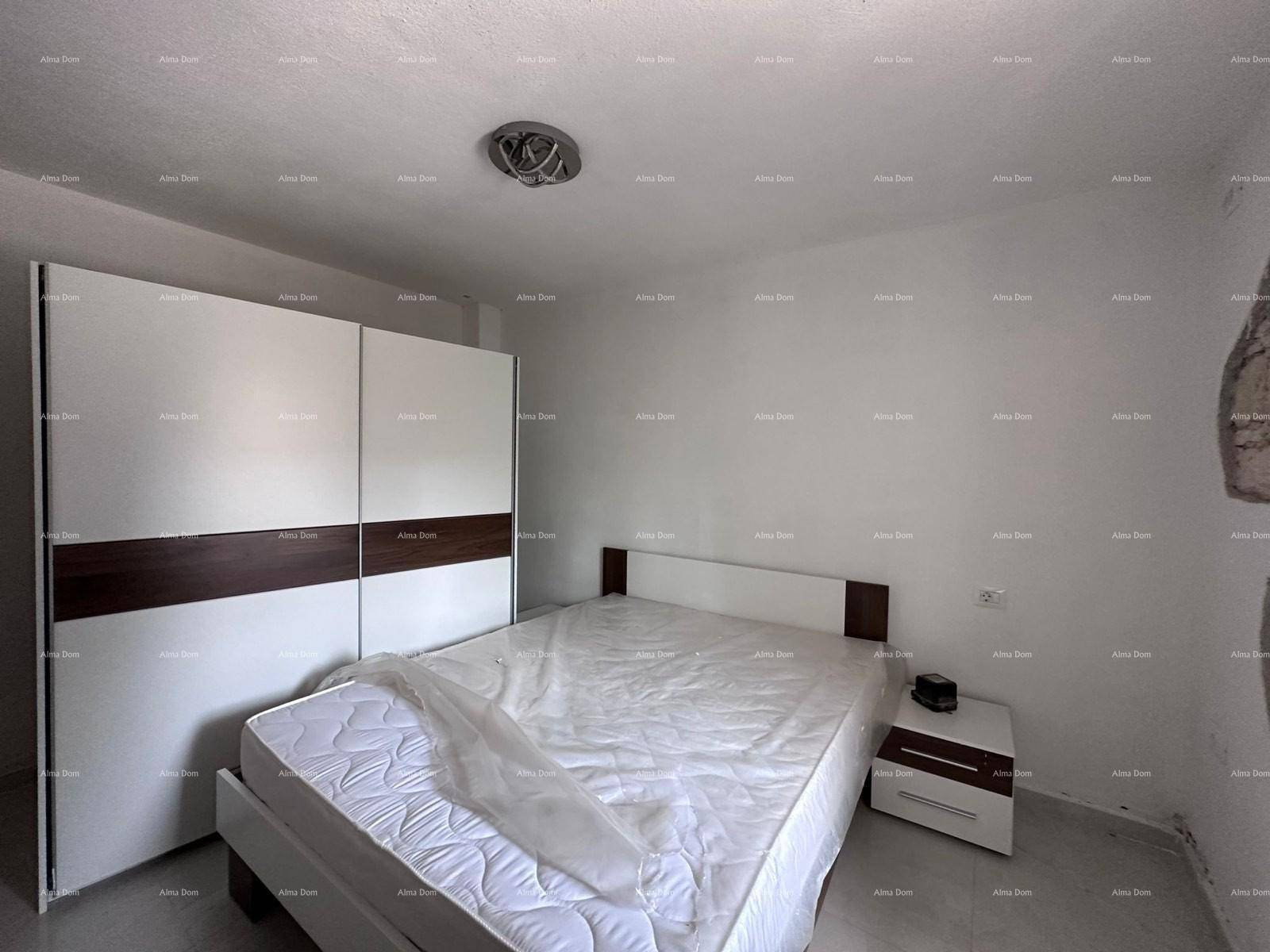 Helles Schlafzimmer mit einem Doppelbett und einem großen, modernen Kleiderschrank.