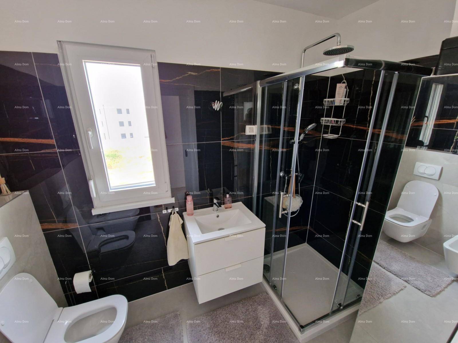 Modernes Badezimmer mit schwarzen Hochglanzfliesen, Duschkabine und Fenster.