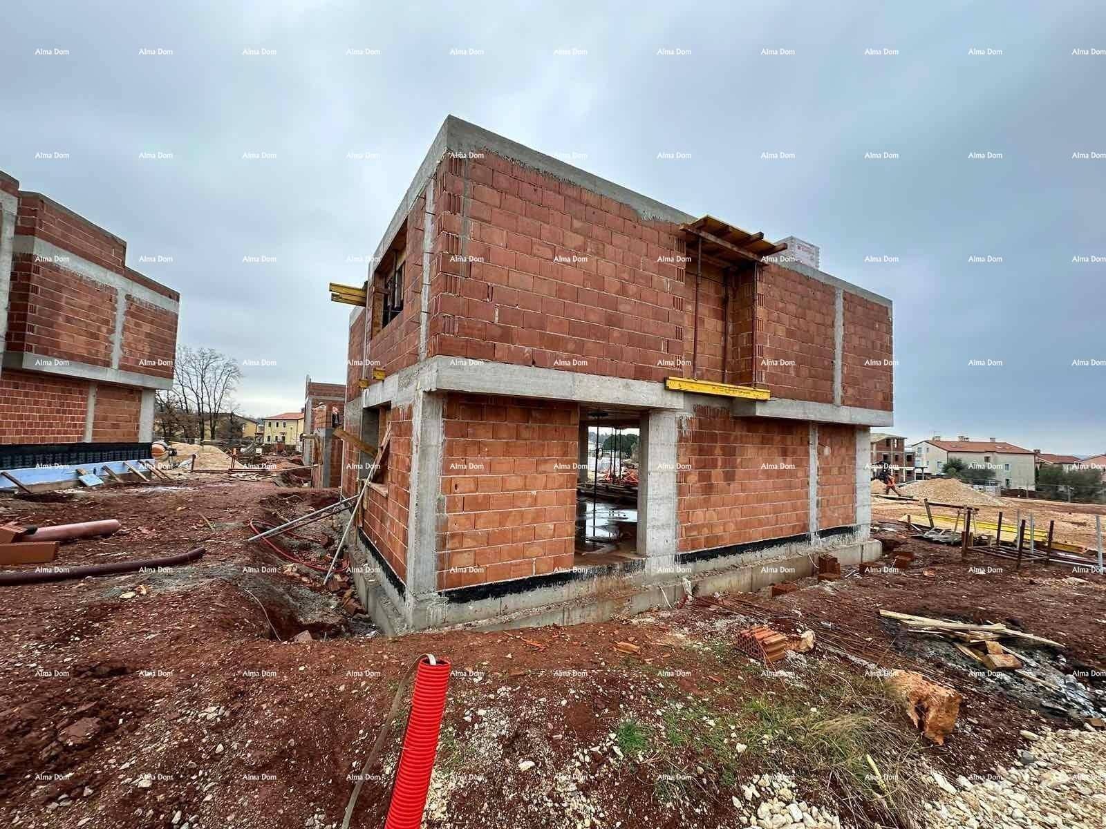 Rohbau eines Hauses mit Ziegelwänden und Betonfundament auf einer Baustelle.