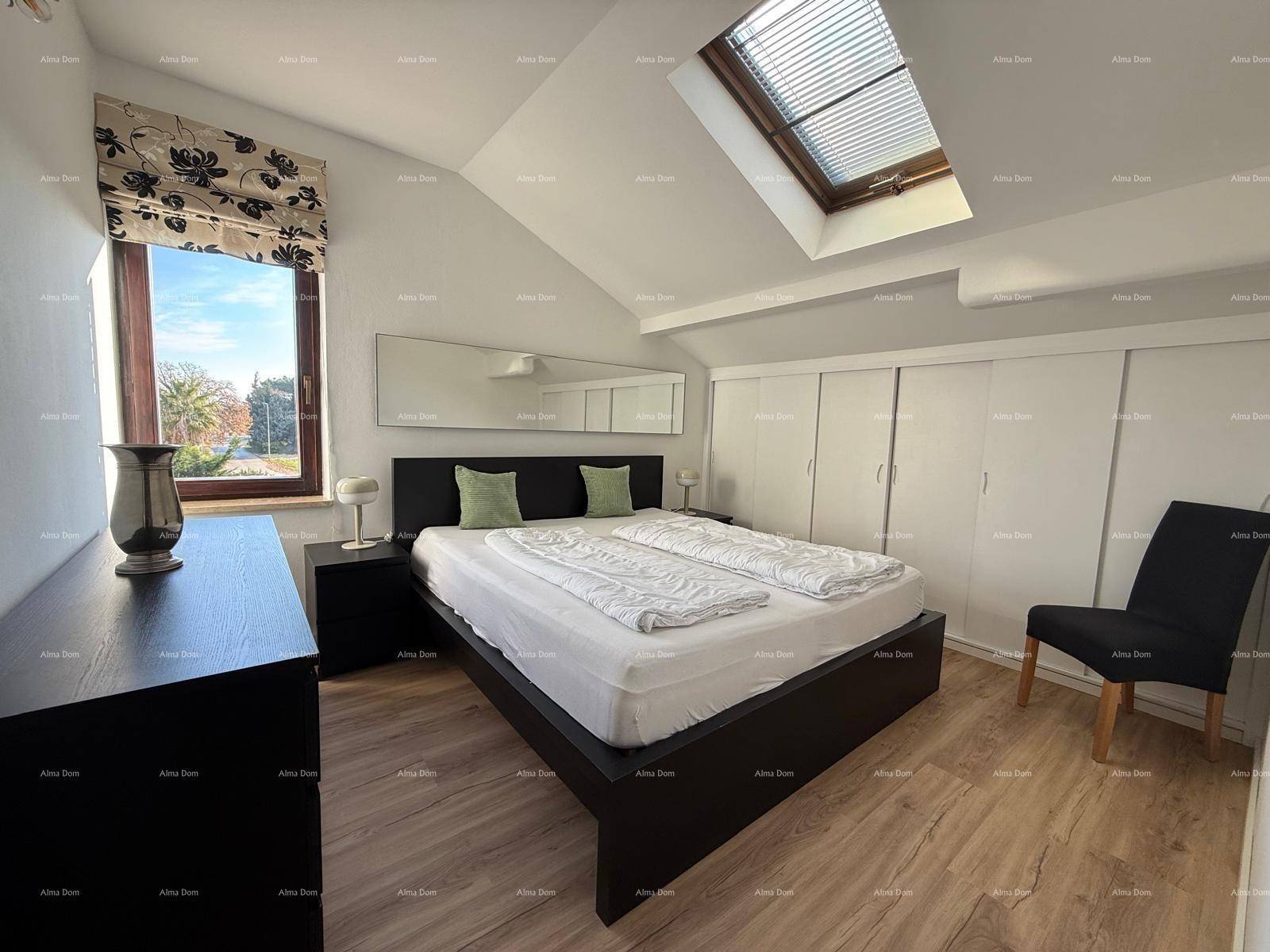 Helles Schlafzimmer mit Doppelbett, Dachfenster und Einbauschränken.