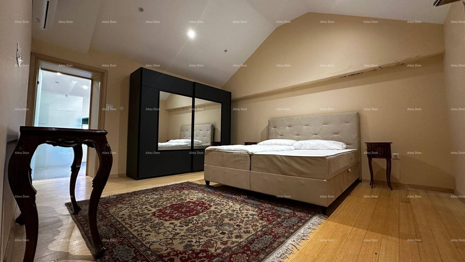 Schlafzimmer mit Doppelbett, Holzboden, schräger Decke und großem Spiegelschrank.