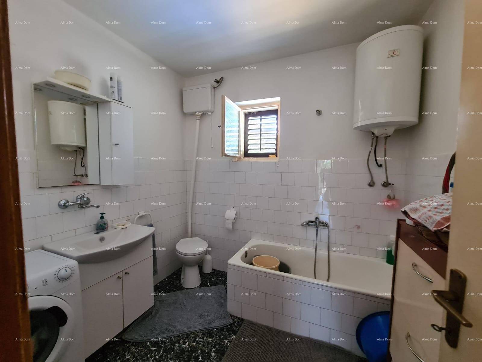 Badezimmer mit Badewanne, Waschbecken, Toilette und Waschmaschine, ausgestattet mit weißen Fliesen.