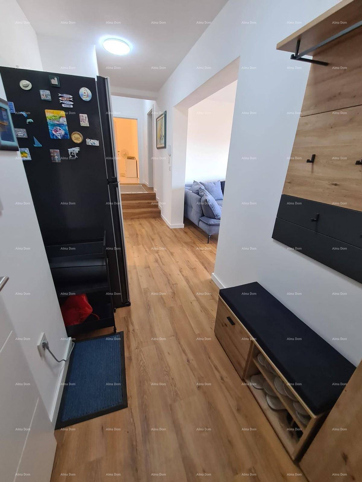 Langer Flur mit Holzboden, der zum Wohnbereich und einer Treppe führt, mit praktischer Garderobe.