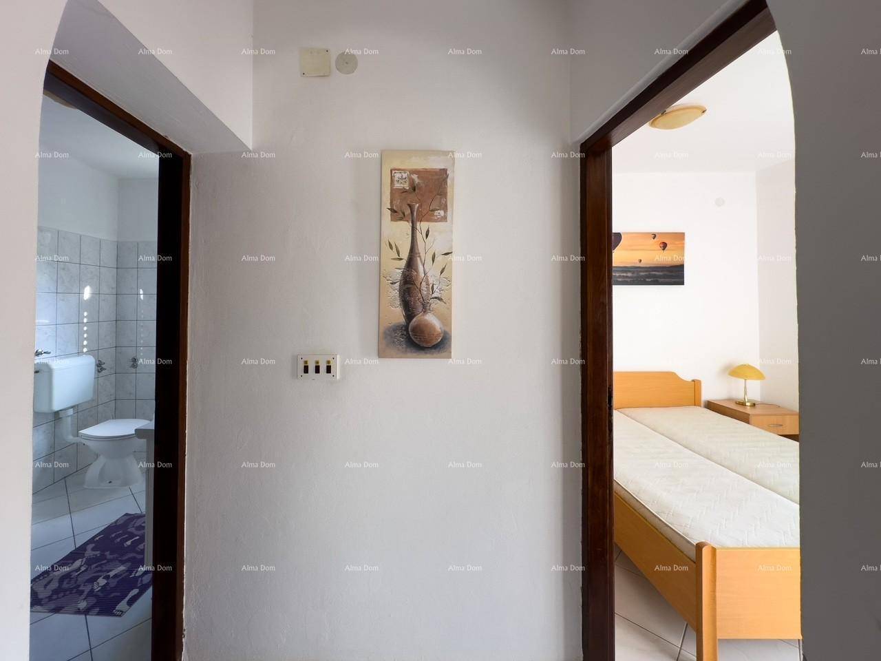 Flur mit zwei Türen, die zu einem Badezimmer mit Toilette und einem Schlafzimmer führen.
