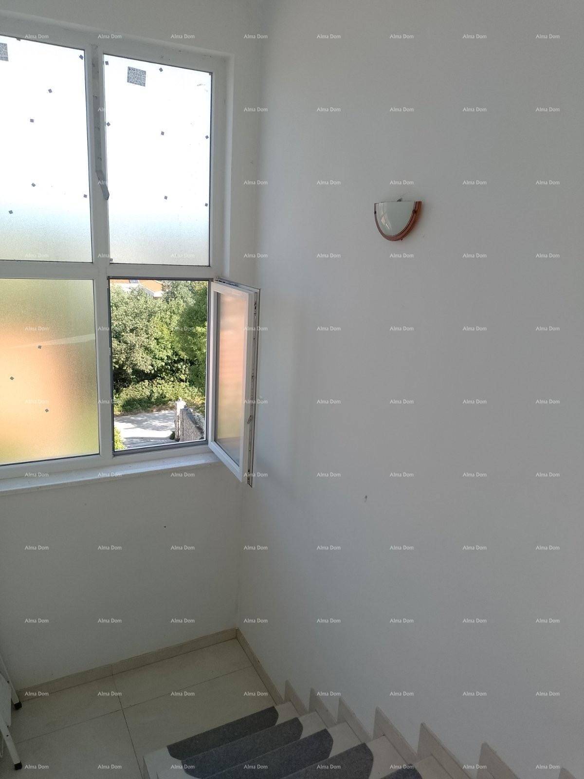 Treppenhaus mit Fliesenboden und einem geöffneten Fenster, das frische Luft hereinlässt.
