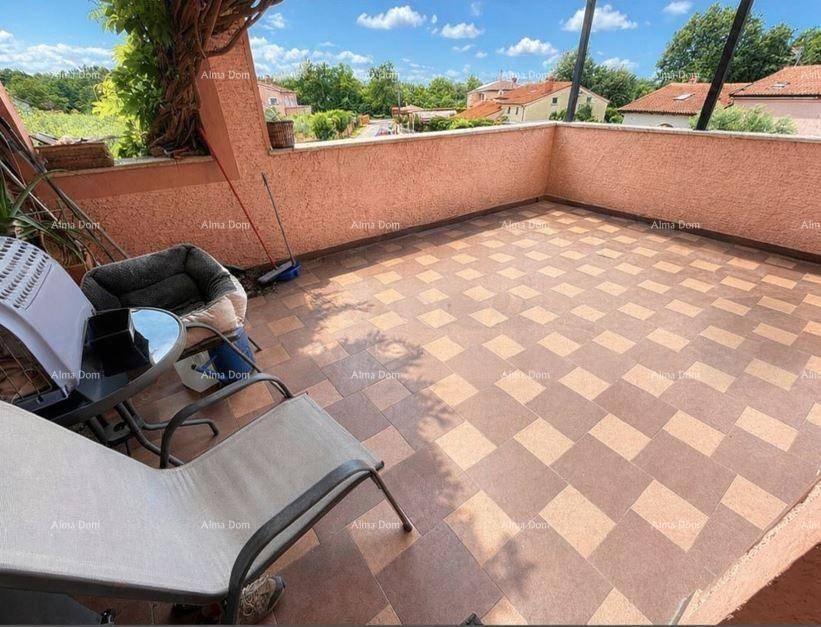 Geräumige geflieste Terrasse mit Sitzgelegenheiten und Blick auf die Umgebung.