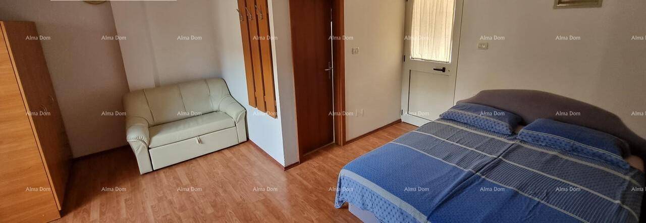 Schlafzimmer mit Doppelbett, Sofa und Holzschrank, bietet zusätzlichen Wohnraum.