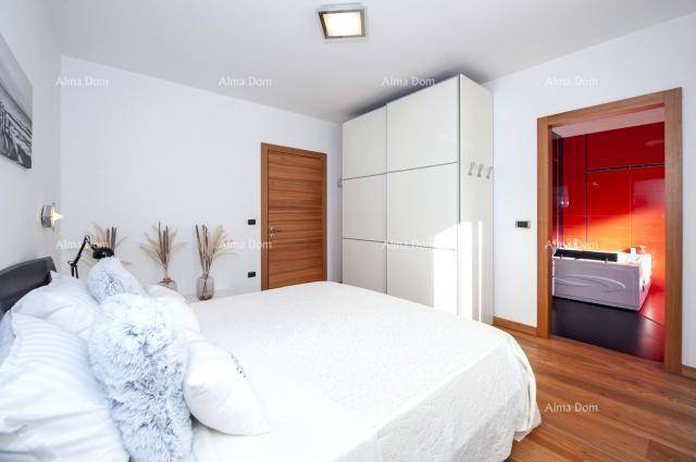 Schlafzimmer mit Holzboden und Zugang zu einem modernen Badezimmer mit Whirlpool.