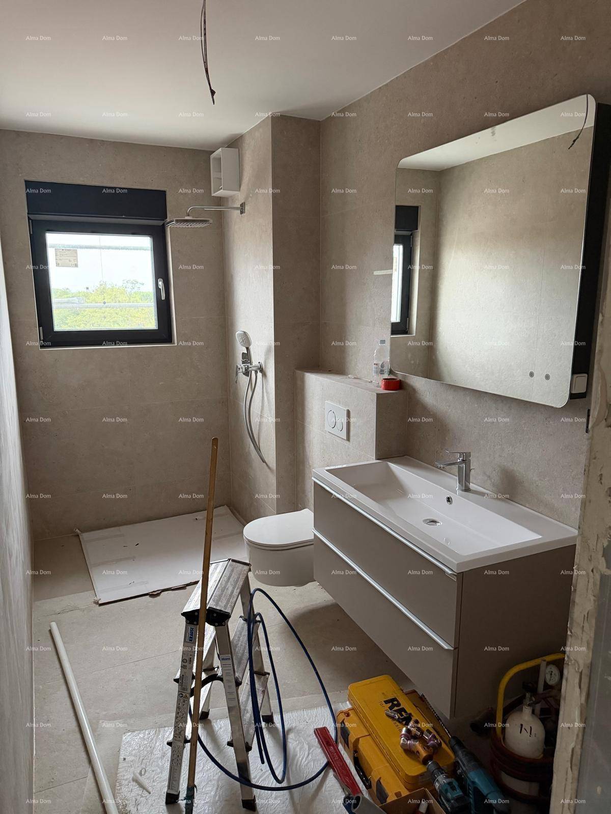 Helles Badezimmer im Bau mit Fenster, Waschtisch, WC und Duschbereich.