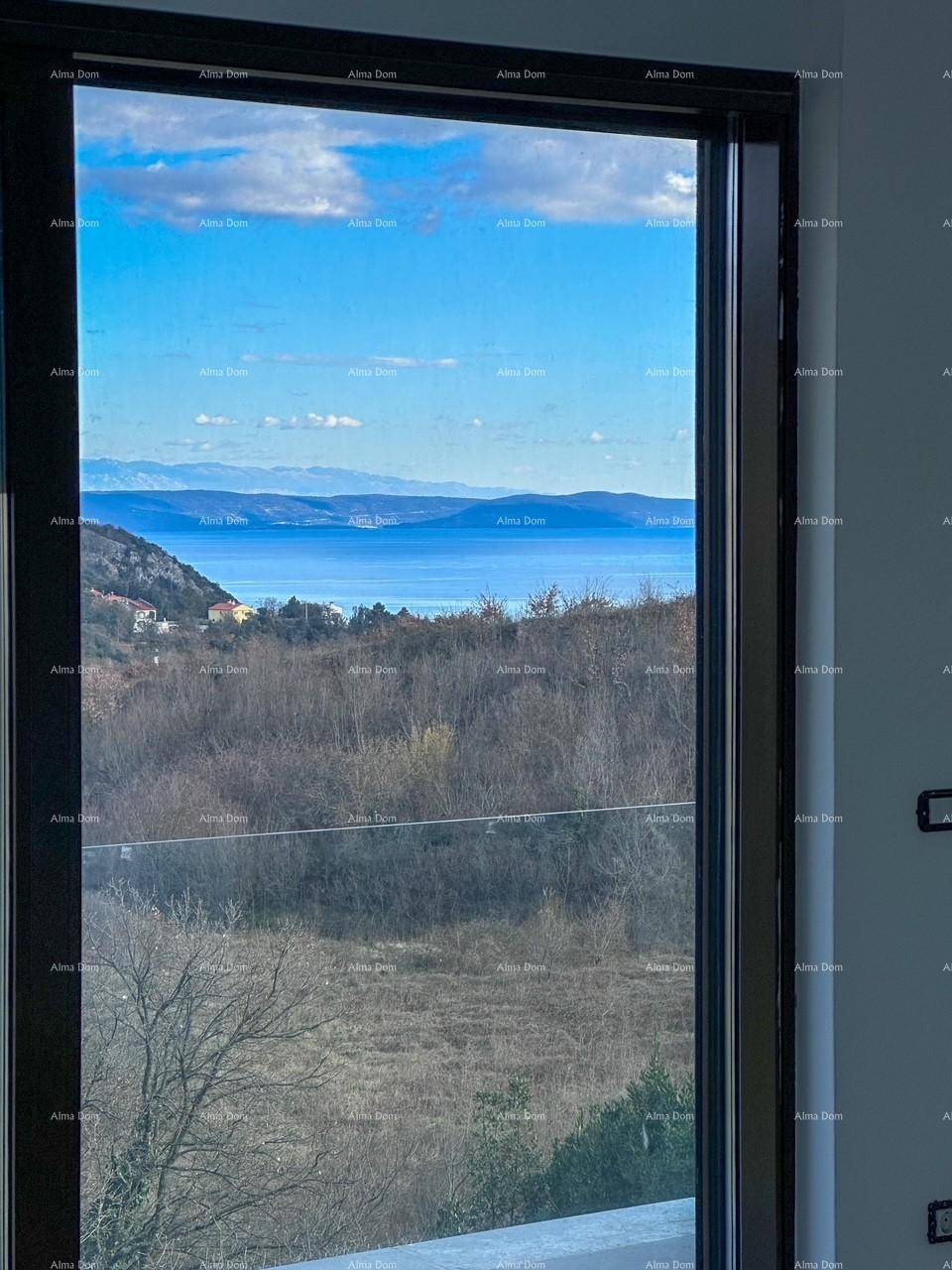 Atemberaubender Meerblick durch ein großes Fenster, umgeben von grüner Landschaft.