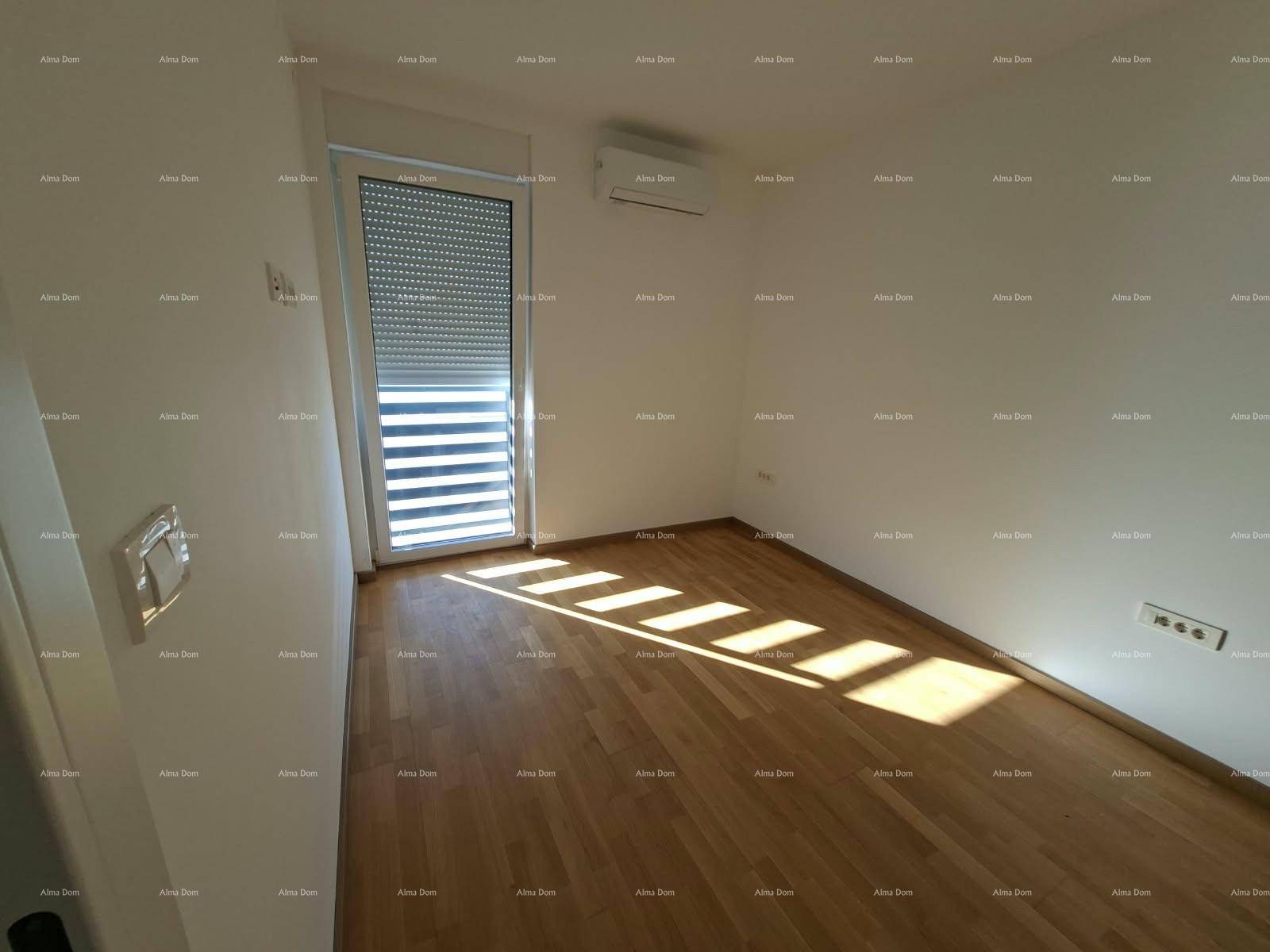 Schlafzimmer mit Holzboden, Klimaanlage und Tür mit Rollladen, die zu einem Außenbereich führt.