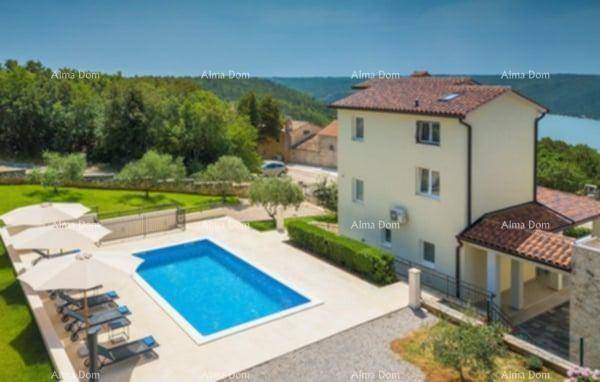 Luftaufnahme des Anwesens mit Poolbereich, Liegestühlen und einem weiten Blick auf das Meer oder einen See.