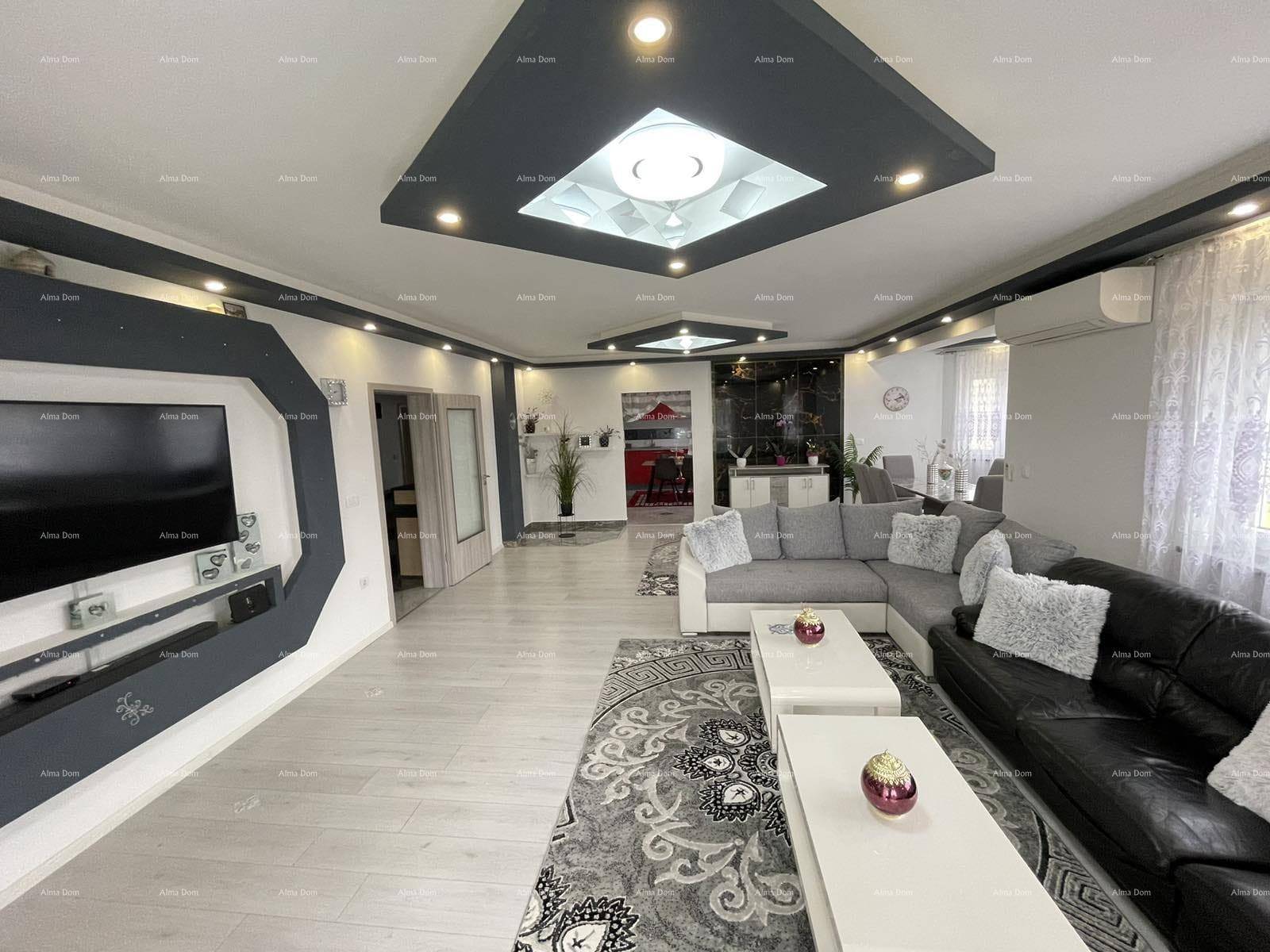 Geräumiger Wohn- und Essbereich mit moderner Einrichtung, Deckenbeleuchtung und großem Sofa.