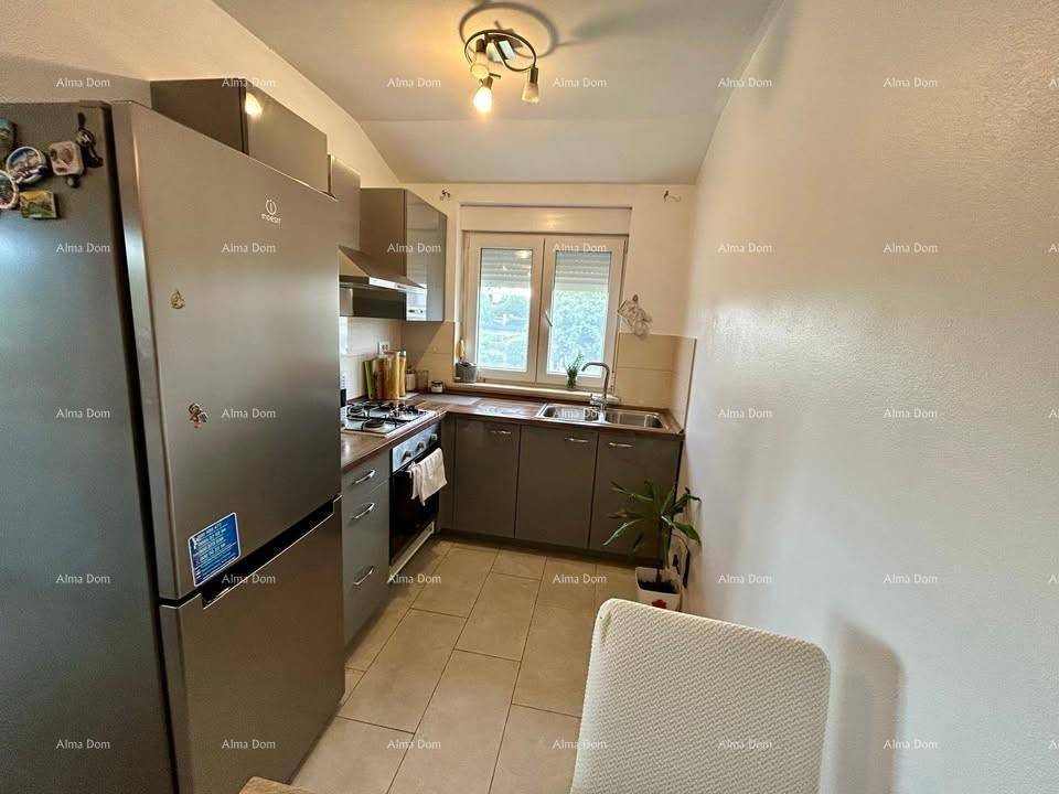 Funktionale Küche mit allen notwendigen Geräten und einem Fenster für natürliches Licht.