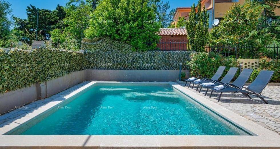 Sonniger Poolbereich mit Liegestühlen und einer grünen Hecke im Hintergrund.