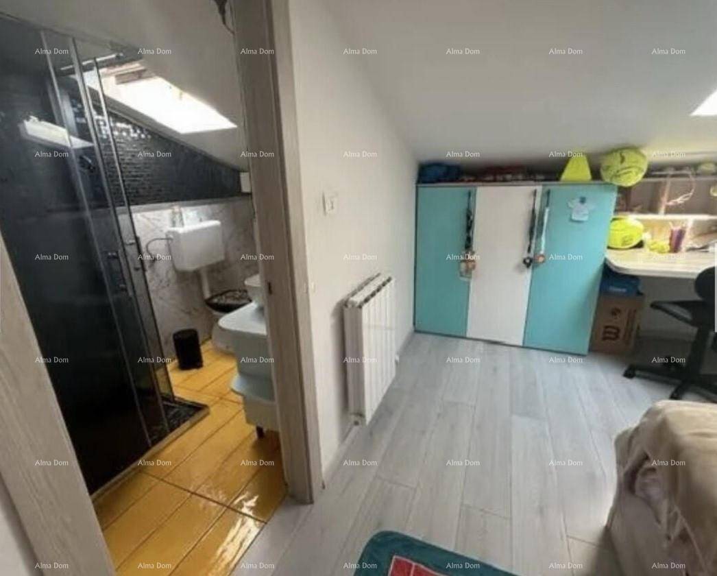 Schlafzimmer mit hellem Laminatboden und Blick auf ein angrenzendes Badezimmer mit Dusche.