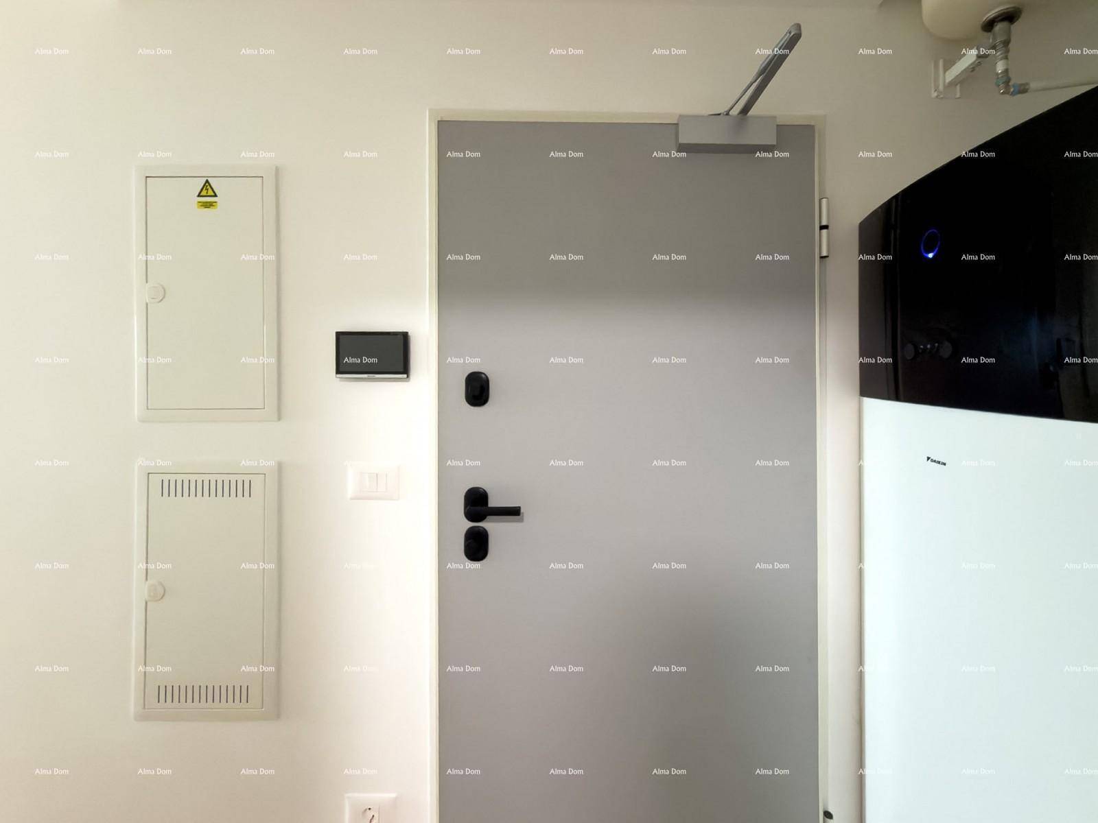 Technikraum mit Eingangstür, elektrischen Schaltkästen und großem Heizgerät.