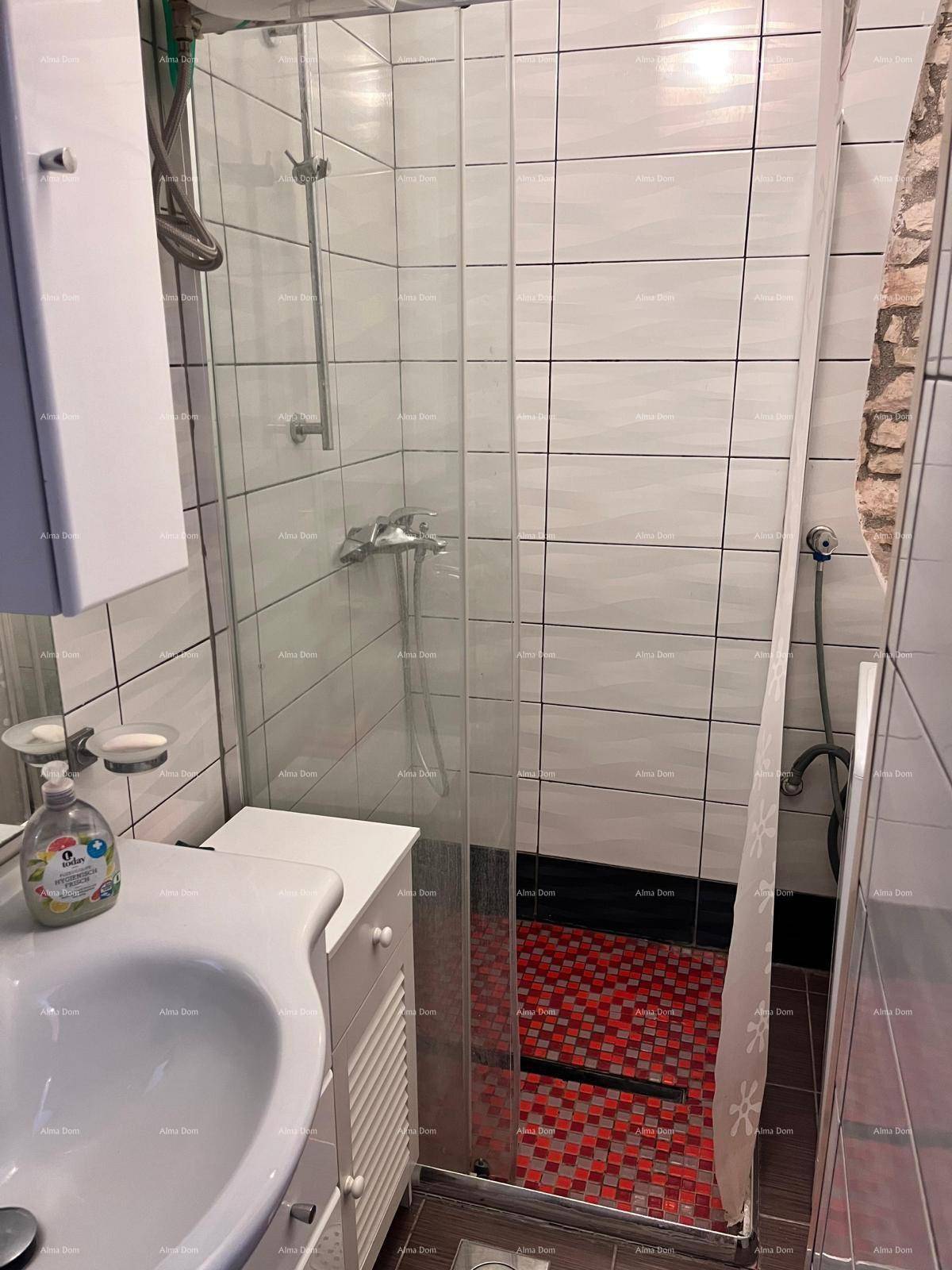 Badezimmer mit Duschkabine, Waschbecken und modernen Fliesen an den Wänden.