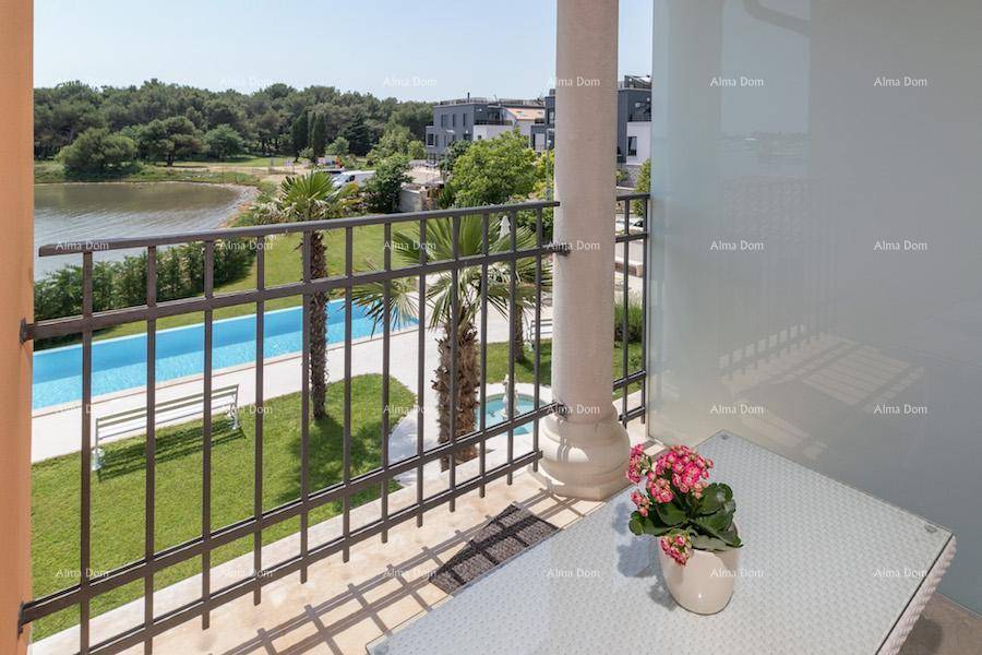 Balkon mit Blick auf den Garten, den Pool und das ruhige Wasser des Sees oder Meeres.