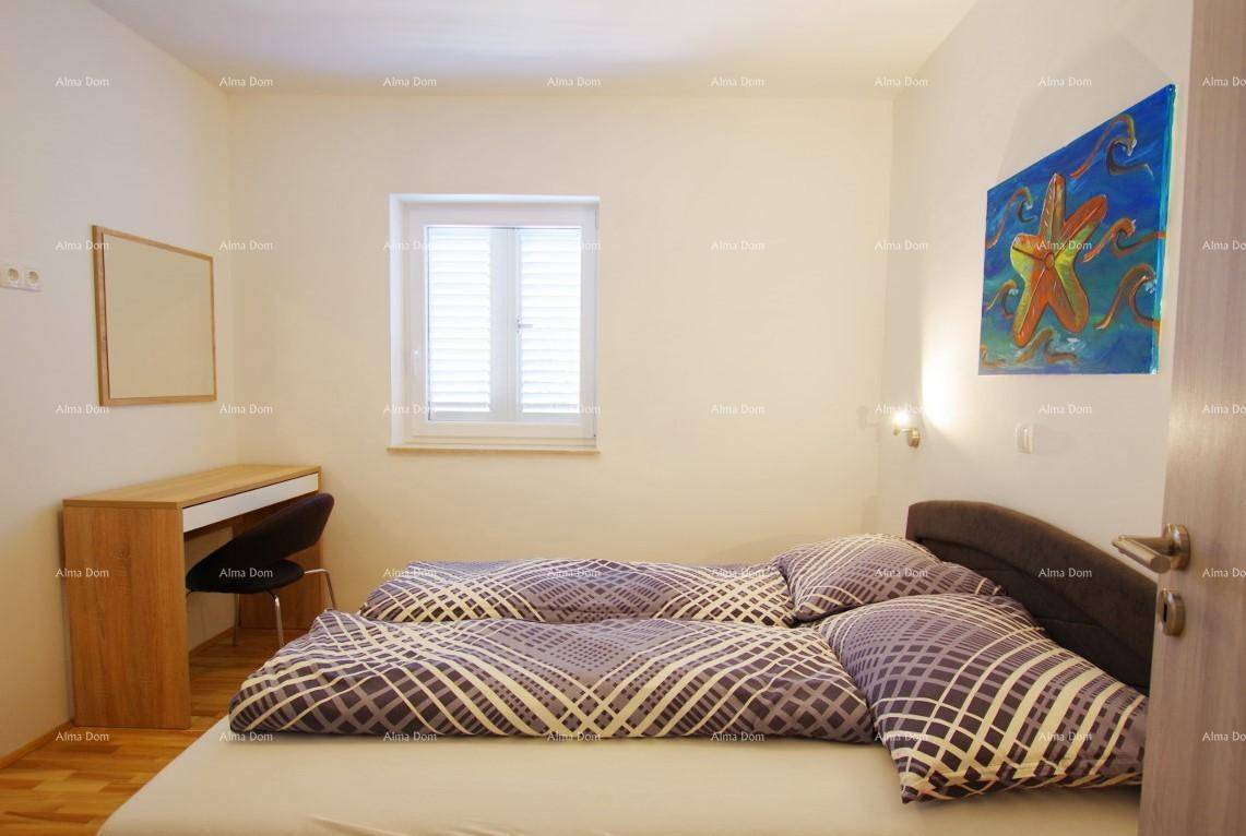 Helles Schlafzimmer mit Holzboden, Doppelbett und einem Fenster mit Jalousien.