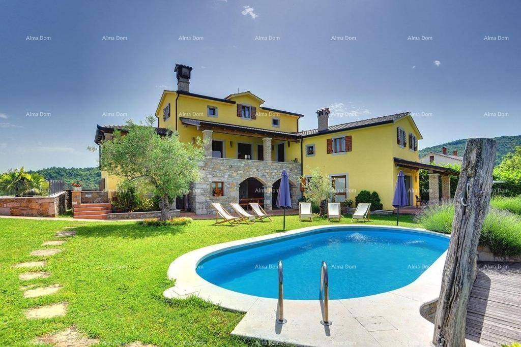 Geräumiger Gartenbereich mit Pool und Sonnenliegen vor der gelben Villa, umgeben von grüner Landschaft.