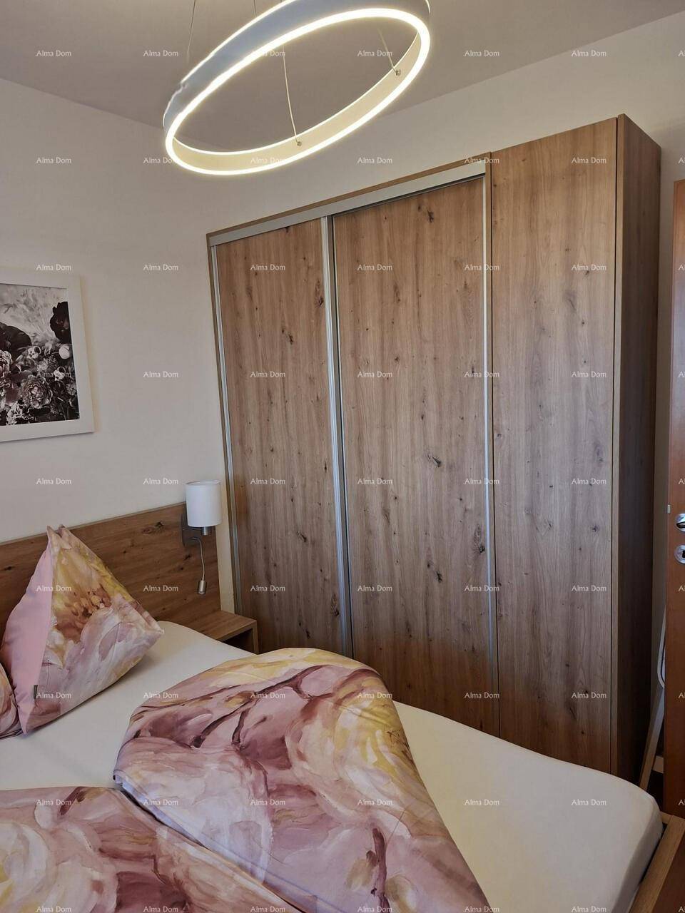 Schlafzimmeransicht mit geräumigem Holzschrank und modernem Deckenlicht.