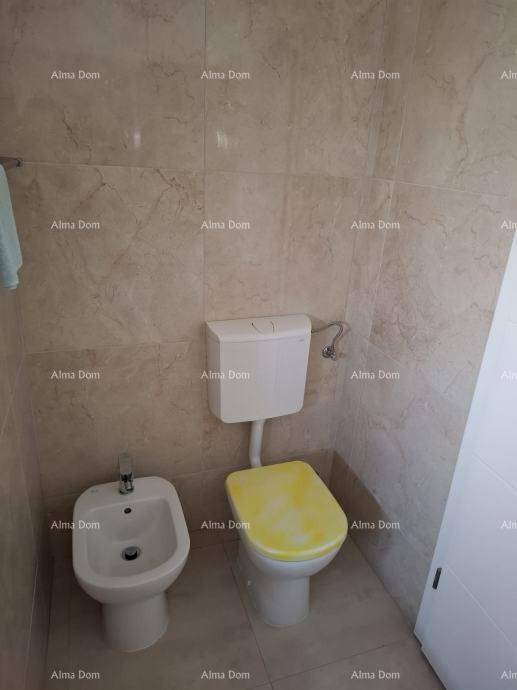 Toilette mit Bidet und WC mit gelbem Sitz, umgeben von hellen Fliesen.