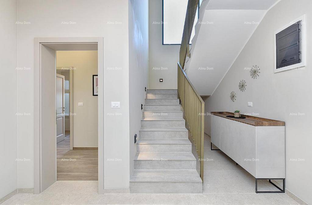 Heller Flur mit moderner Treppe und stilvollem Sideboard, führt zu weiteren Räumen.