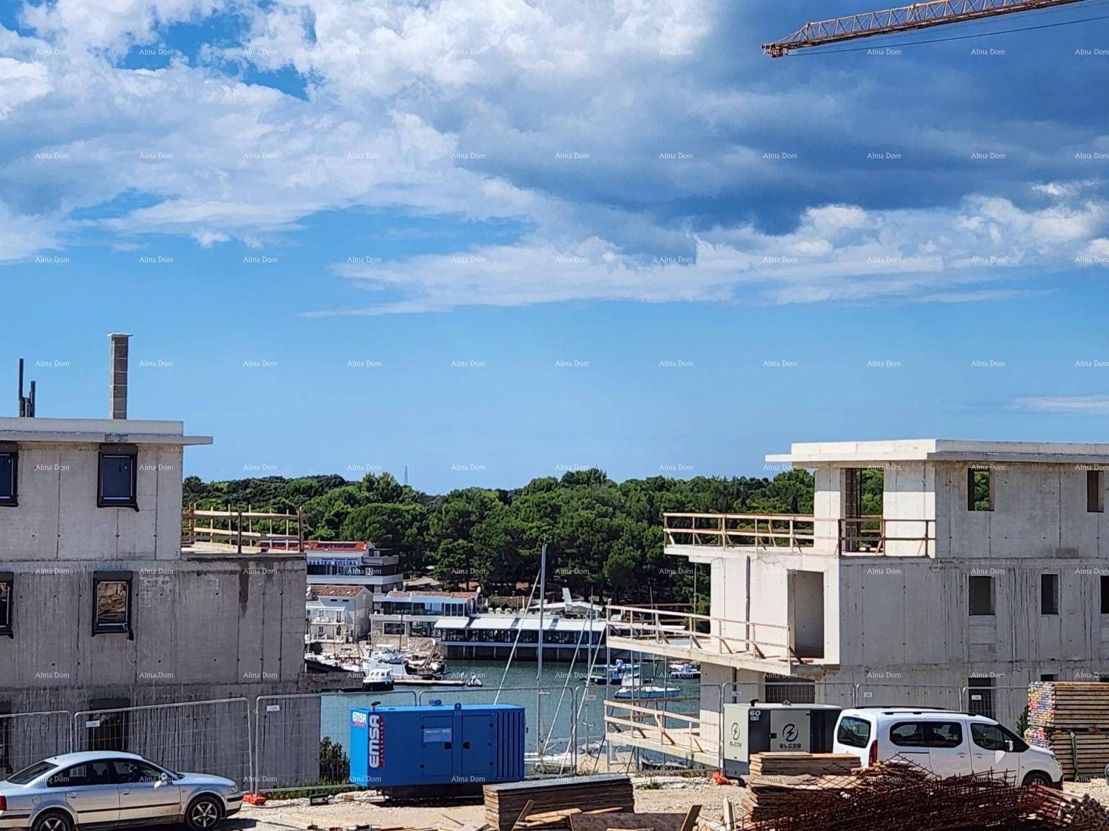 Baustelle mit Blick auf den Hafen und die umliegende grüne Landschaft unter blauem Himmel.