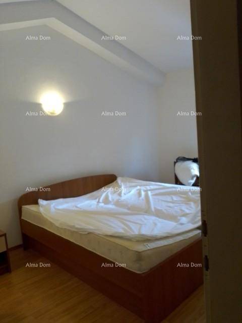 Schlafzimmer mit Holzbett und schrägen Decken, ausgestattet mit einfachem Holzboden.