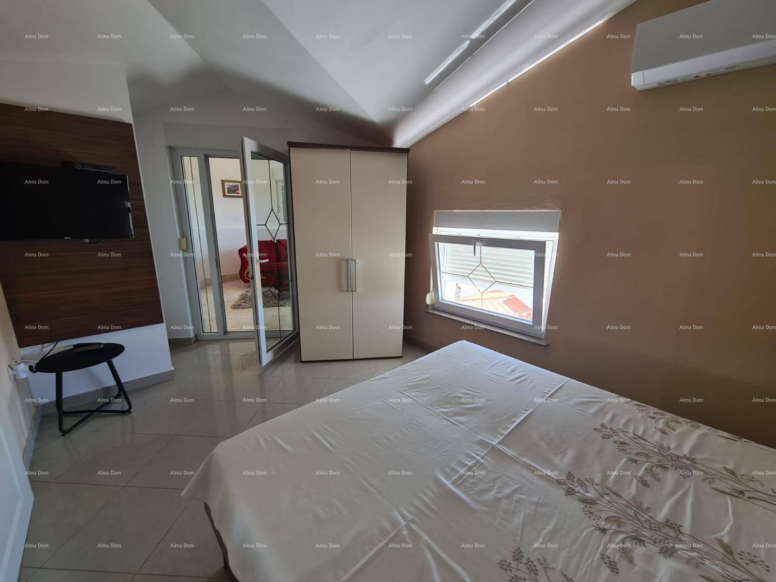 Schlafzimmer mit Bett, Kleiderschrank und Zugang zu einem angrenzenden Raum.