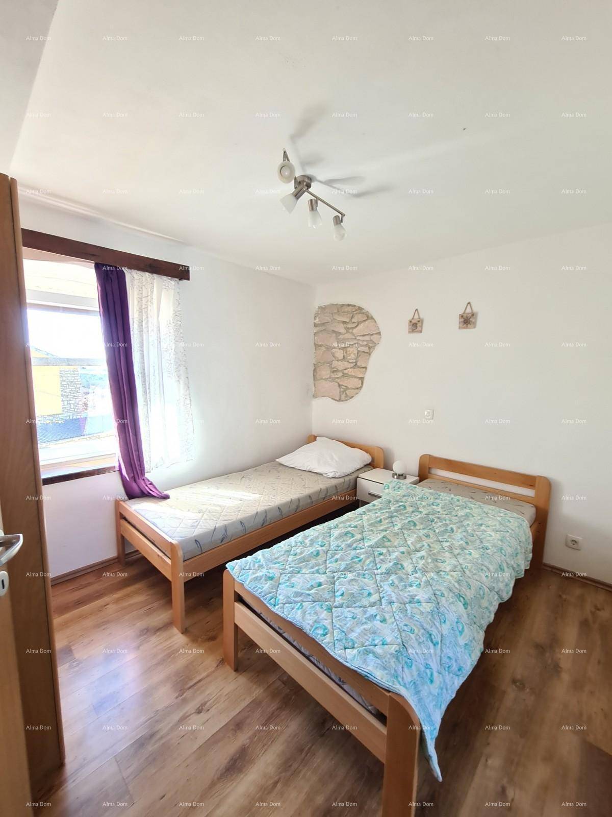 Schlafzimmer mit zwei Einzelbetten, Holzboden und Fenster.