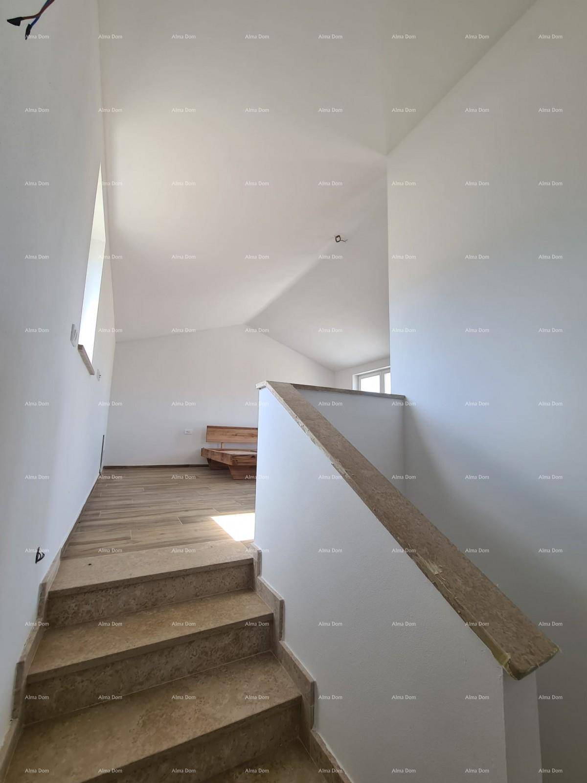 Heller Treppenaufgang mit Steinstufen und schrägen Decken in einem Neubau.